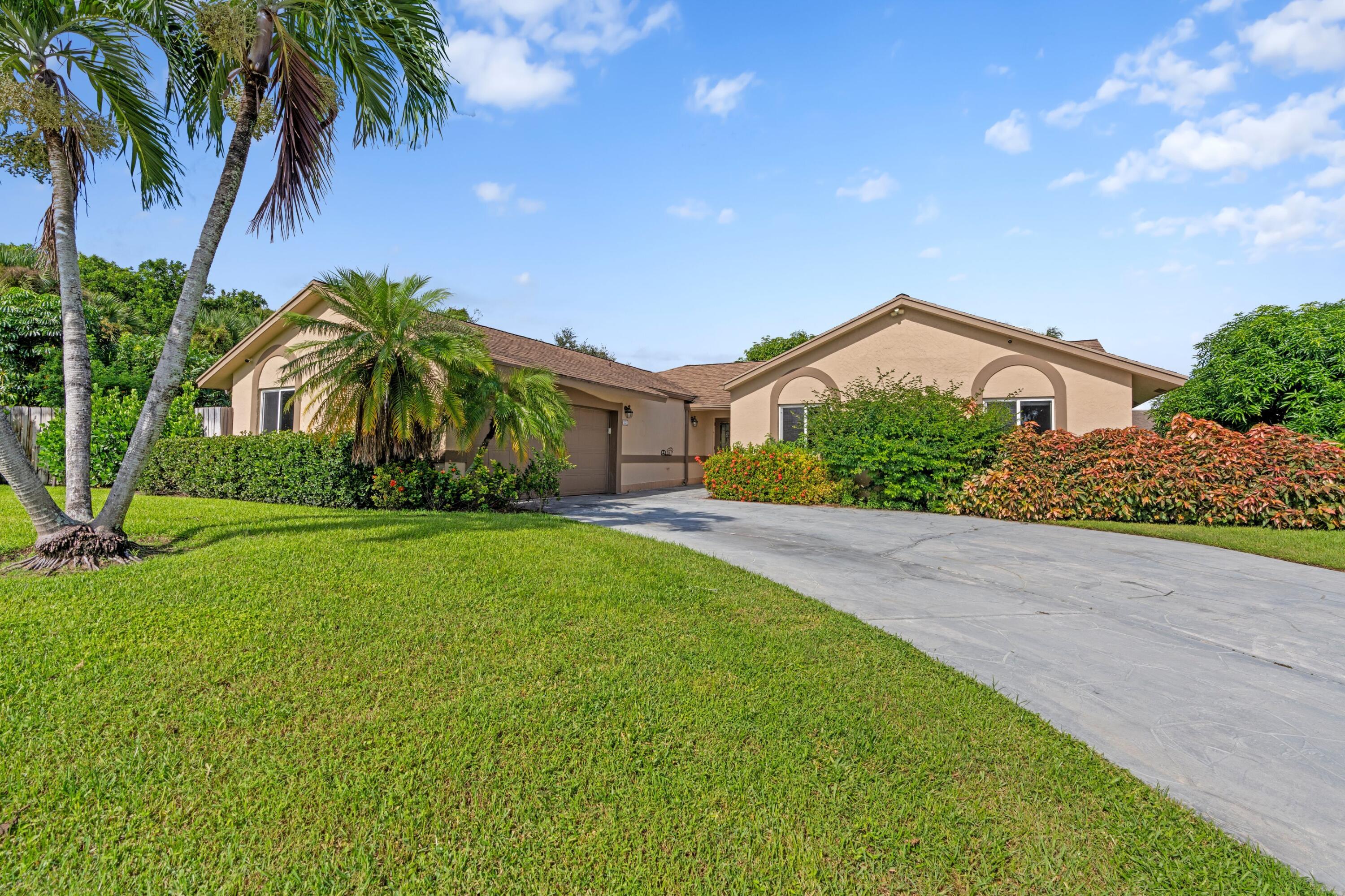 1431 Rudder Cove Wellington, FL 33414 - Photo 2 of 22 a front view of house with yard and green space