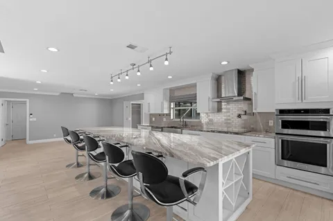 a kitchen with stainless steel appliances granite countertop a stove a sink and a microwave