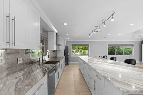 a large kitchen with stainless steel appliances lots of counter top space