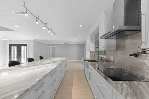 a large white kitchen with a large window