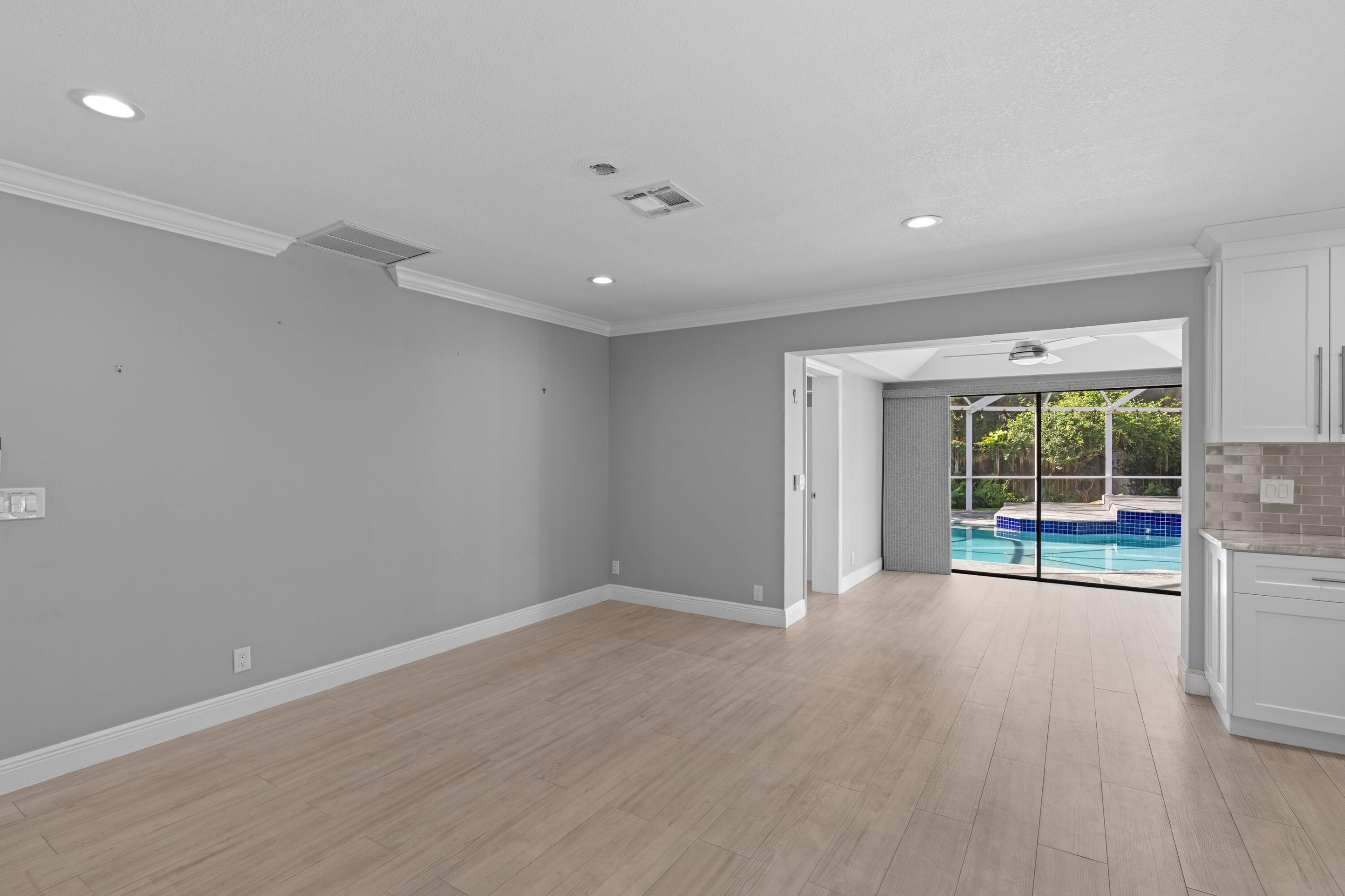 1431 Rudder Cove Wellington, FL 33414 - Photo 9 of 22 a view of an empty room with wooden floor and a window