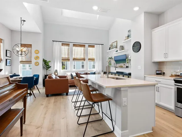 a living room with stainless steel appliances kitchen island granite countertop furniture and a large window