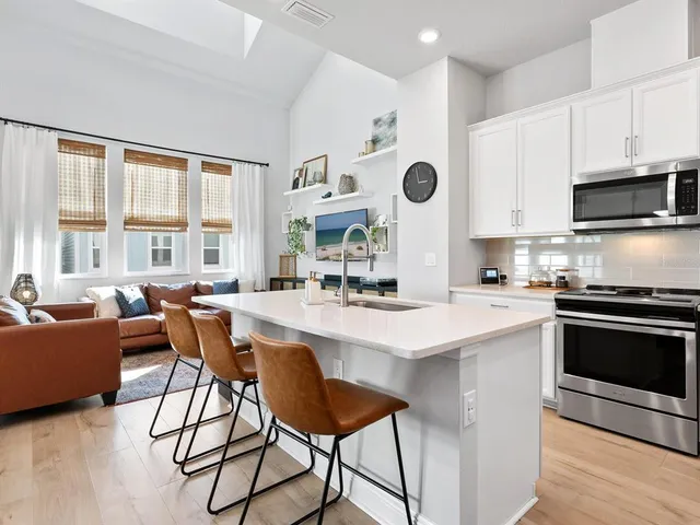 a kitchen with stainless steel appliances kitchen island a large window and cabinets