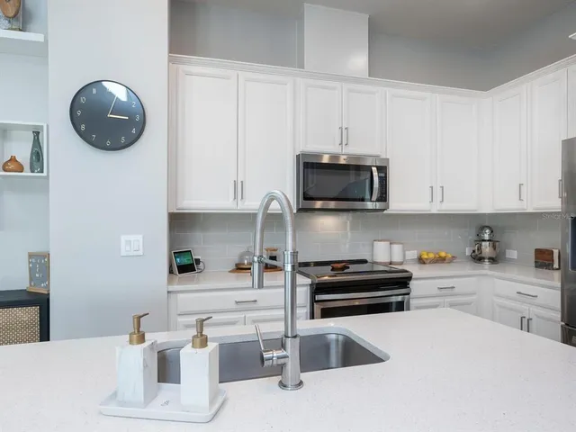a kitchen with stainless steel appliances kitchen island granite countertop a sink and a microwave
