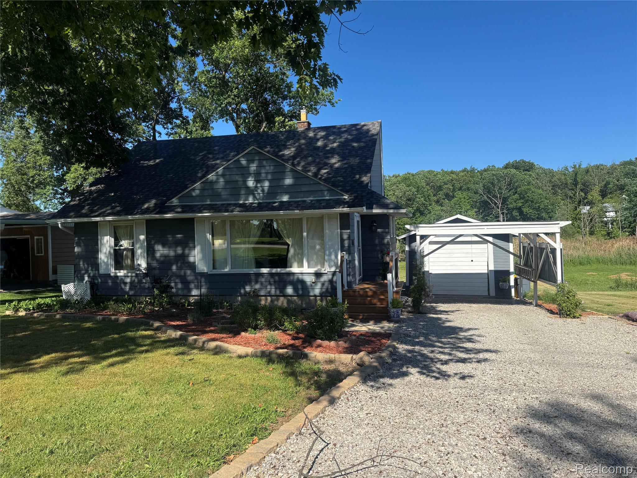 22827 Meridian Road Grosse Ile, MI 48138 - Photo 1 of 36 Charming home featuring gray siding, white window trim, and a dark shingled roof