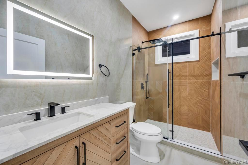 472 Farm Ranch Road East Bethpage, NY 11714 - Photo 20 of 26 a bathroom with a sink a toilet a mirror and shower