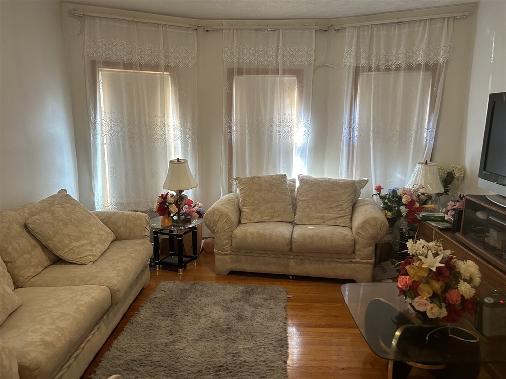 16 Hampshire Street Everett, MA 02149 - Photo 2 of 8 a living room with furniture and a large mirror