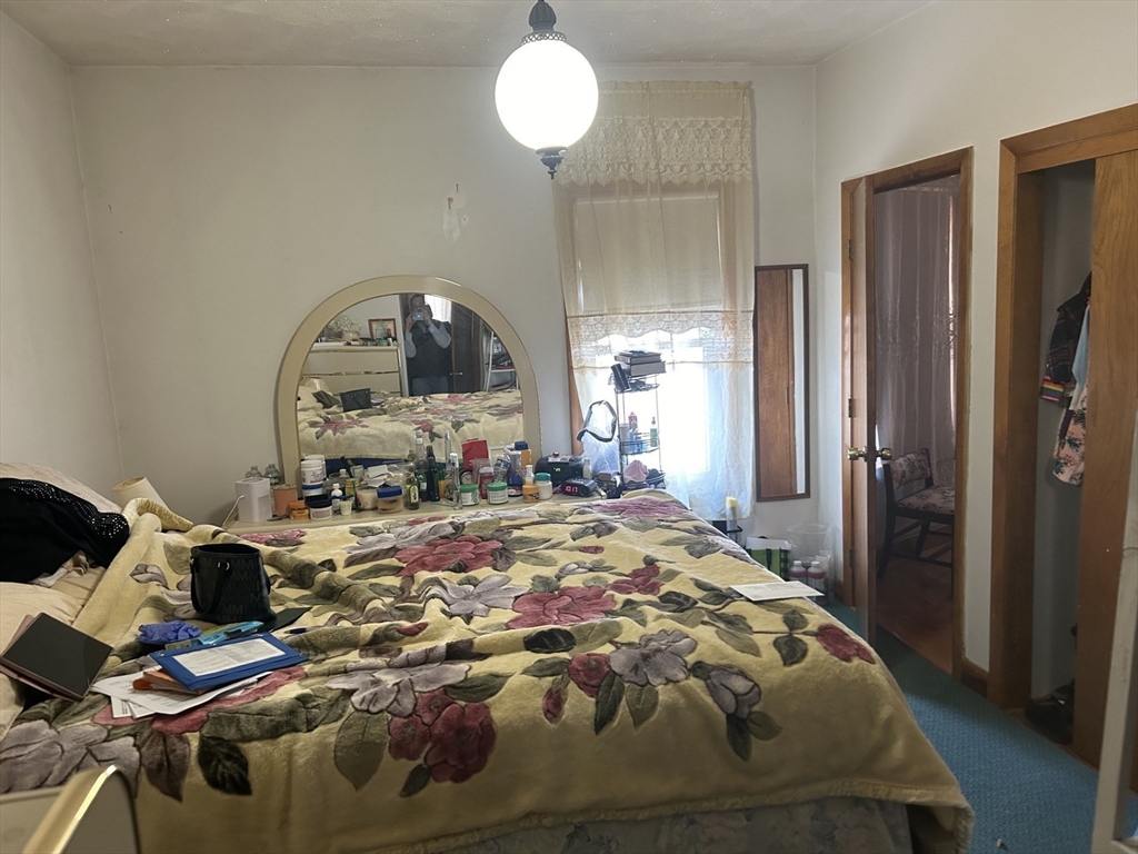 16 Hampshire Street Everett, MA 02149 - Photo 4 of 8 a bed sitting in a bedroom next to a window