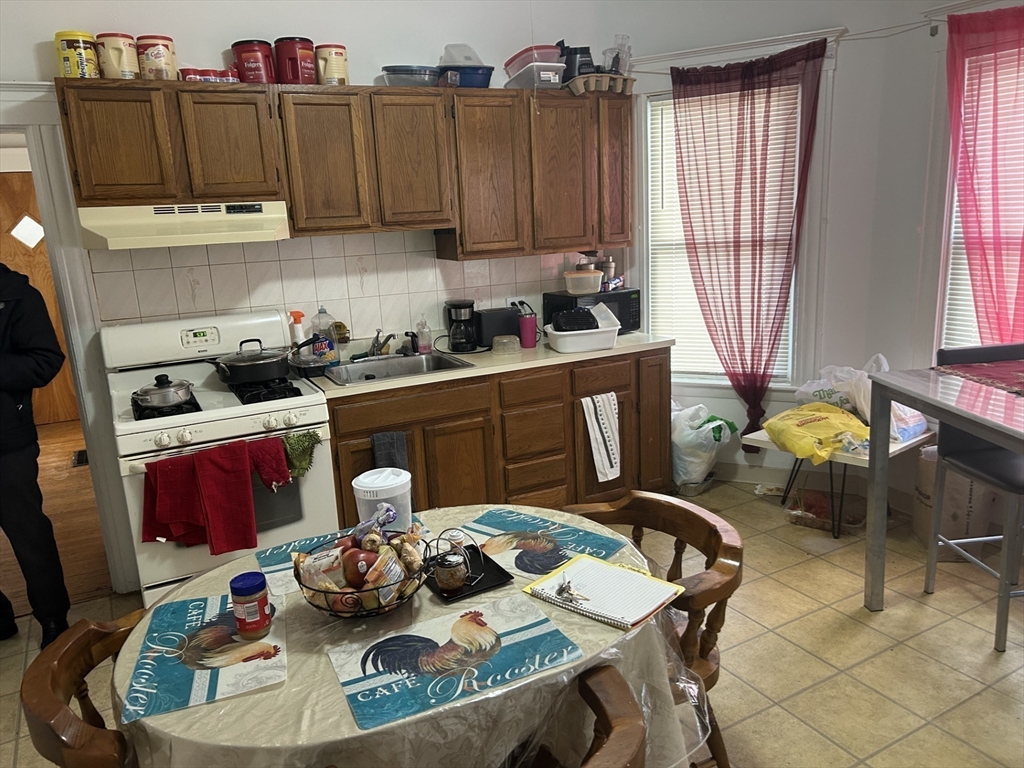 16 Hampshire Street Everett, MA 02149 - Photo 5 of 8 a kitchen with a refrigerator and a stove top oven