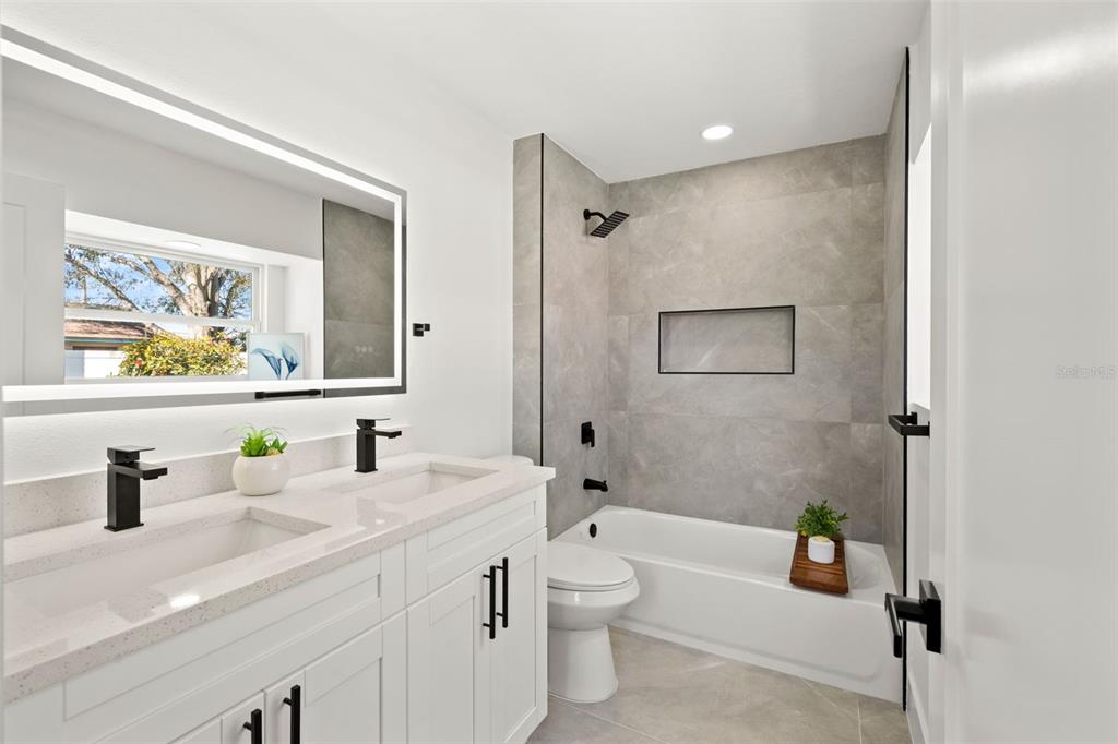 12671 115th Street Largo, FL 33778 - Photo 25 of 39 a bathroom with a double vanity sink toilet and shower