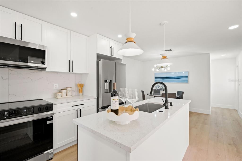 12671 115th Street Largo, FL 33778 - Photo 6 of 39 a kitchen with stainless steel appliances a sink a stove and a microwave