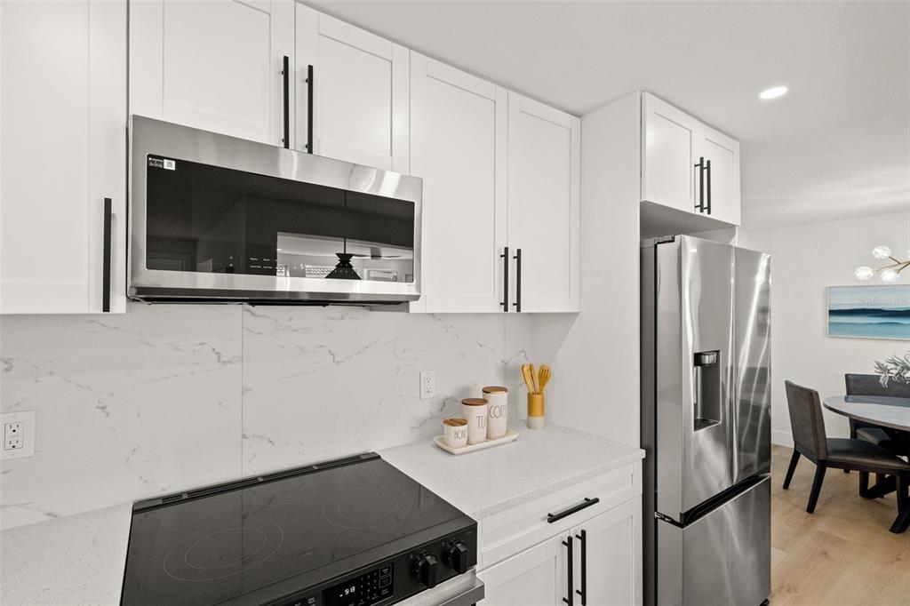 12671 115th Street Largo, FL 33778 - Photo 8 of 39 a kitchen with stainless steel appliances a refrigerator a stove a microwave and cabinets