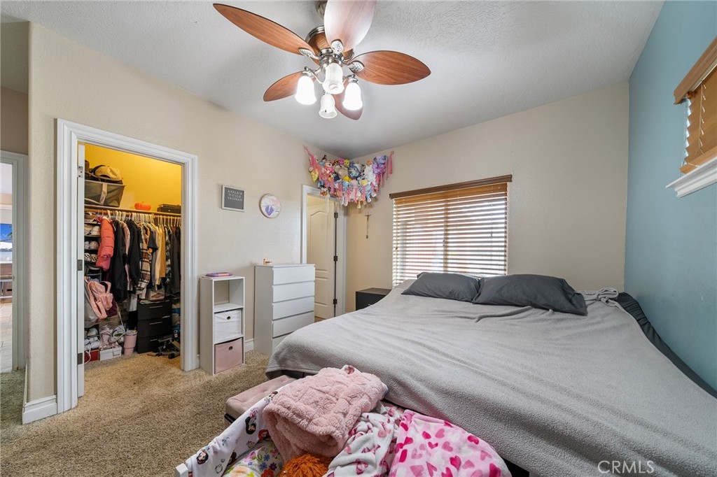 7172 Jargon Road Hesperia, CA 92344 - Photo 24 of 75 a bedroom with a bed and a chandelier