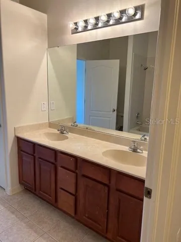 a bathroom with a double vanity sink and large mirror