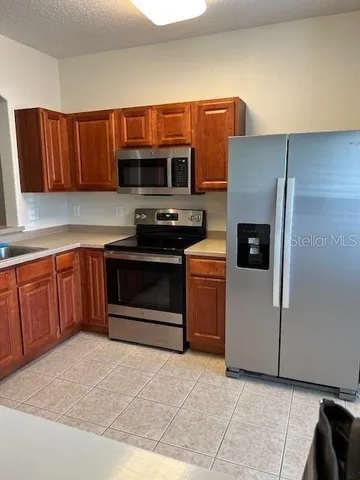 a kitchen with stainless steel appliances a stove a refrigerator and a sink