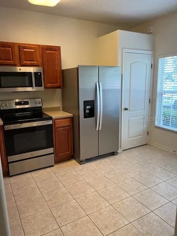 a kitchen with stainless steel appliances granite countertop a refrigerator and a stove top oven