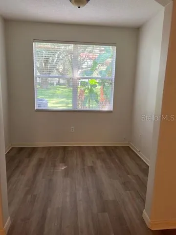 an empty room with wooden floor and a window