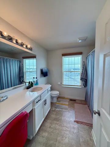 a spacious bathroom with a granite countertop sink a mirror and a bathtub