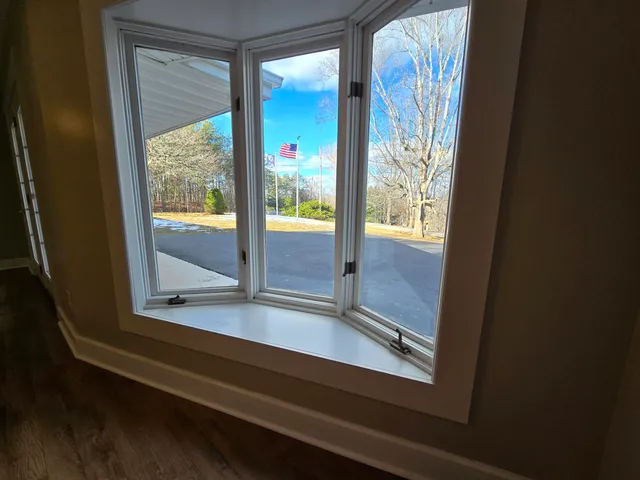 a view of wooden floor and a chandelier fan in a room