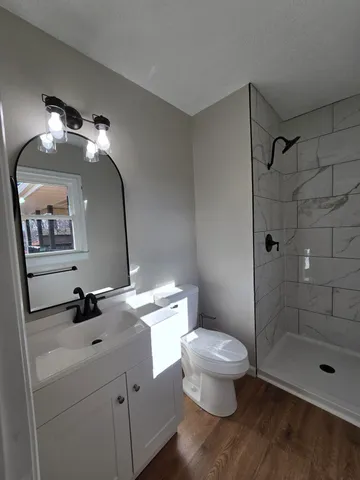 a bathroom with a granite countertop sink toilet and shower