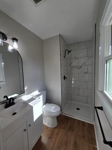 a bathroom with a granite countertop sink toilet and shower