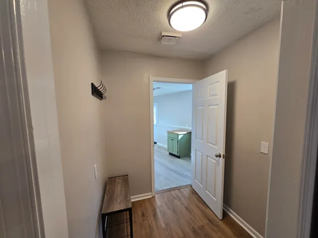 a view of a hallway with wooden floor