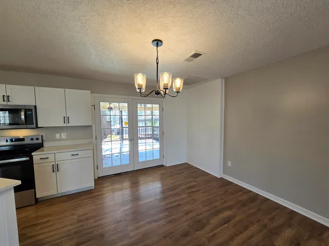 a view of a kitchen with a stove wooden cabinet a kitchen view and wooden floor