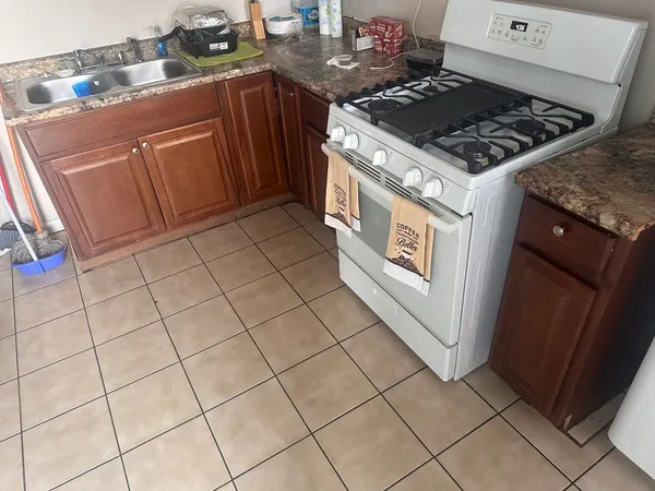 a kitchen with a stove a microwave a sink and cabinets