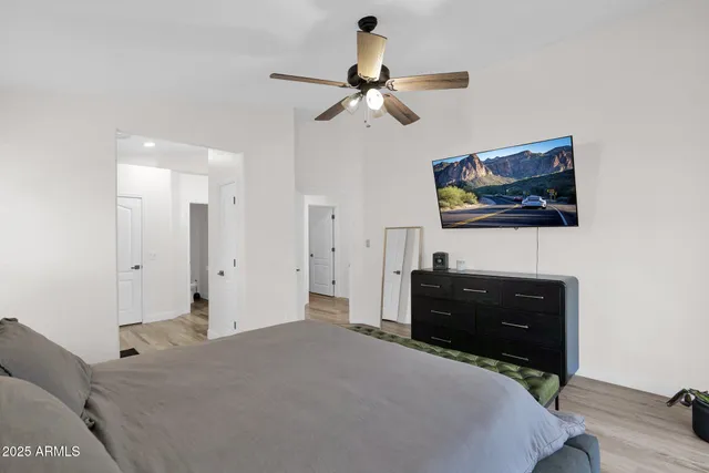 a bedroom with a bed and a flat tv screen on dresser