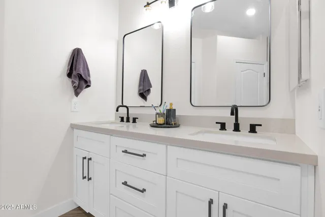 a bathroom with a double vanity sink and a mirror