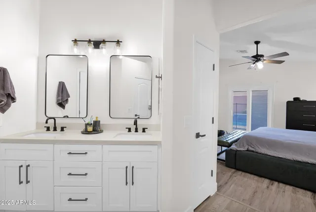 a bedroom with a double bed sink and mirror