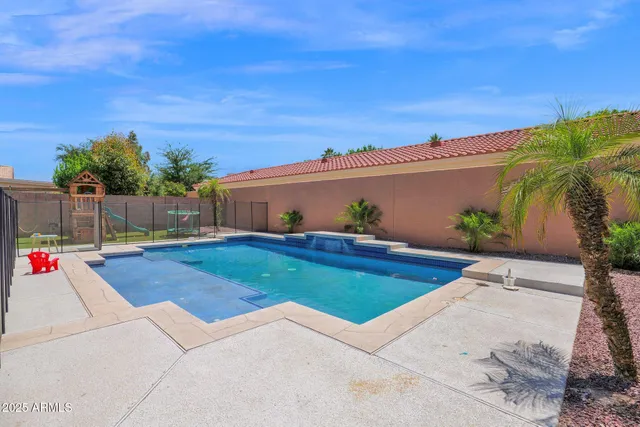 a view of swimming pool with outdoor seating and wooden fence