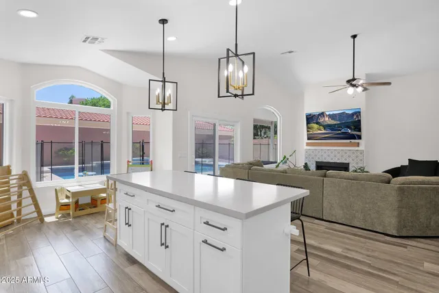 a kitchen with stainless steel appliances granite countertop a sink a oven and a wooden floor