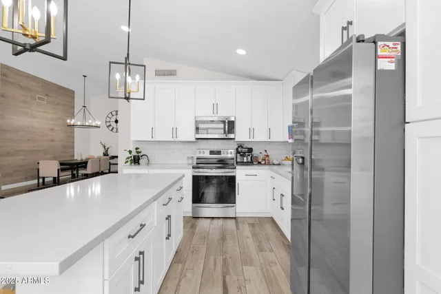a kitchen with stainless steel appliances a refrigerator sink and cabinets