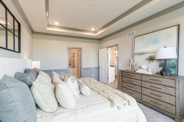 a spacious bedroom with a bed and a dresser