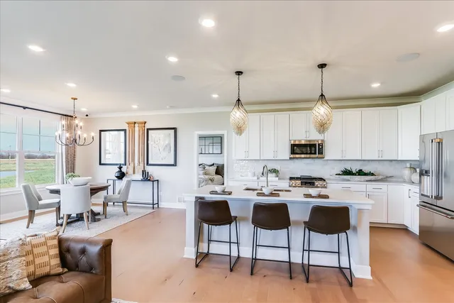 a large kitchen with cabinets chairs and white appliances