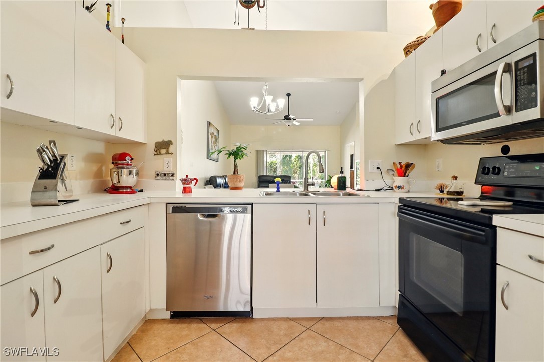 6283 Shadowood Circle Naples, FL 34112 - Photo 12 of 31 a kitchen with white cabinets and white appliances