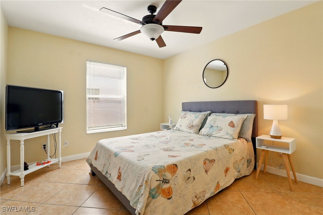 6283 Shadowood Circle Naples, FL 34112 - Photo 13 of 31 a bedroom with a bed and a flat screen tv