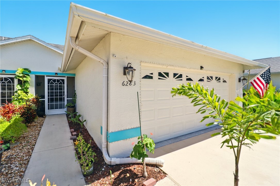 6283 Shadowood Circle Naples, FL 34112 - Photo 2 of 31 a potted plant sitting in front of a door