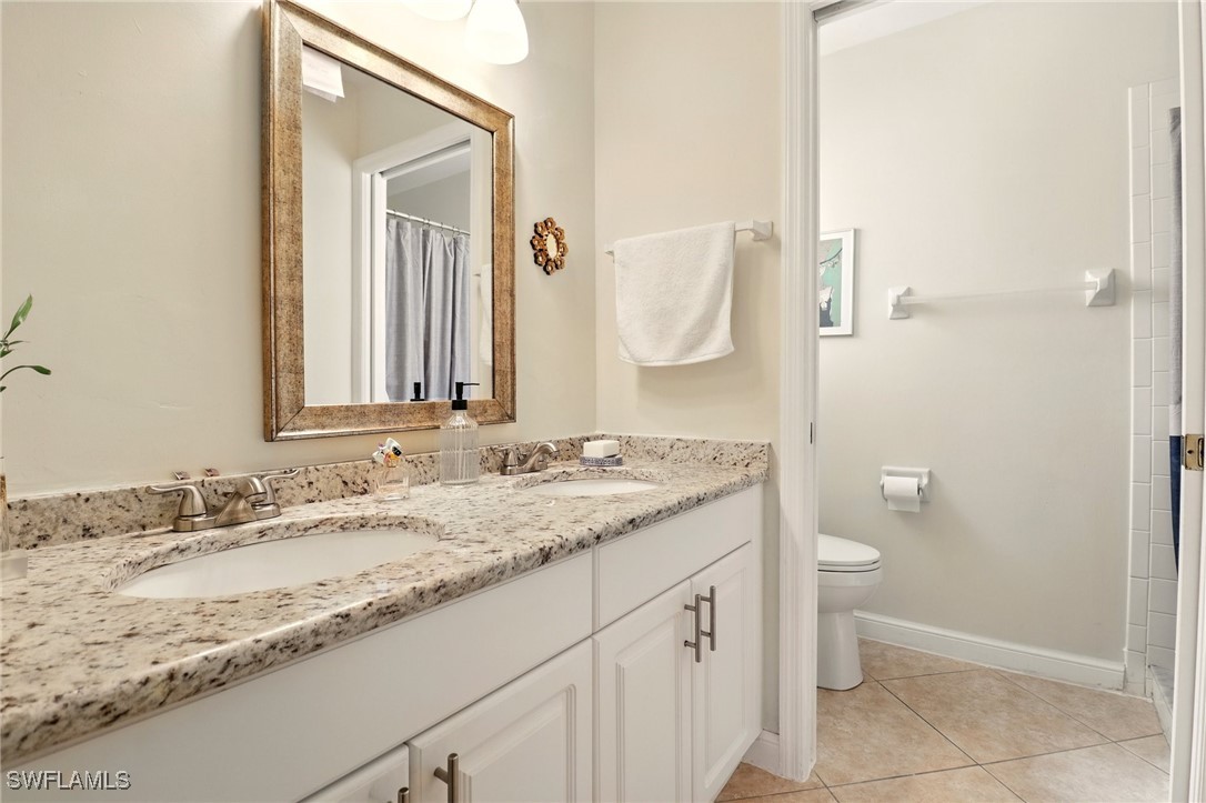 6283 Shadowood Circle Naples, FL 34112 - Photo 21 of 31 a bathroom with a granite countertop sink and a mirror