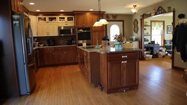 a kitchen with kitchen island granite countertop wooden floors and a sink