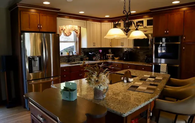 a kitchen with stainless steel appliances granite countertop a sink refrigerator and cabinets