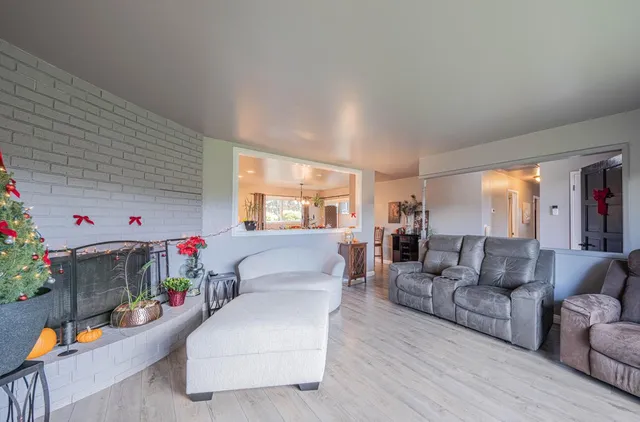 a kitchen with stainless steel appliances granite countertop a stove top oven a sink dishwasher a dining table and chairs with wooden floor