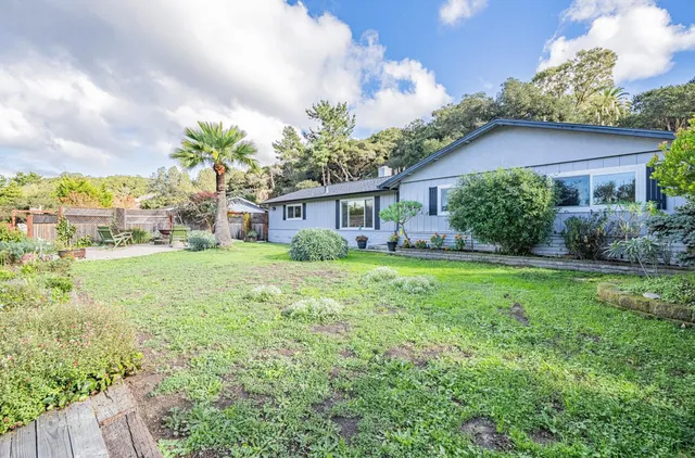 a view of house with yard and green space