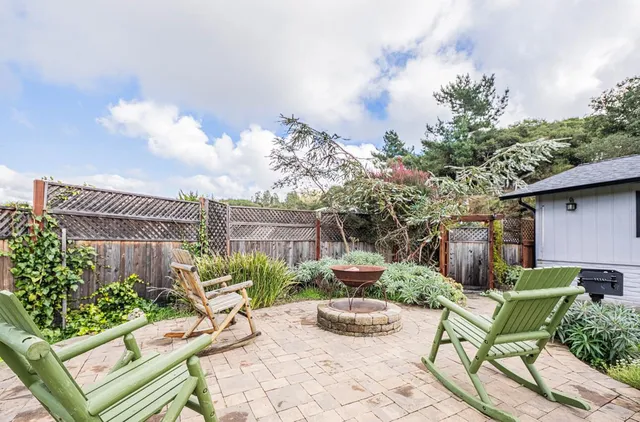 a view of a chair and table in backyard