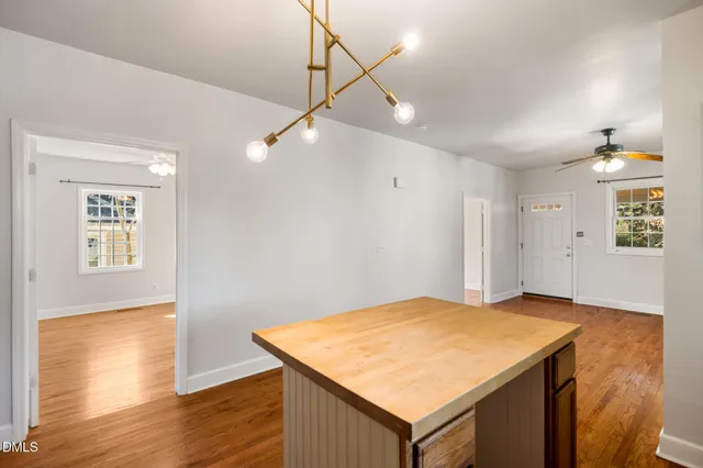 a kitchen with stainless steel appliances granite countertop a refrigerator a sink dishwasher a stove and white countertops with wooden floor