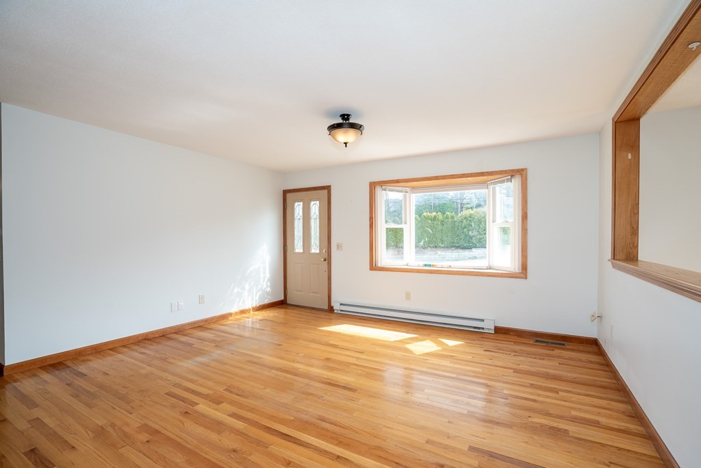 127 Upper Hampden Road Monson, MA 01057 - Photo 16 of 42 an empty room with wooden floor and windows