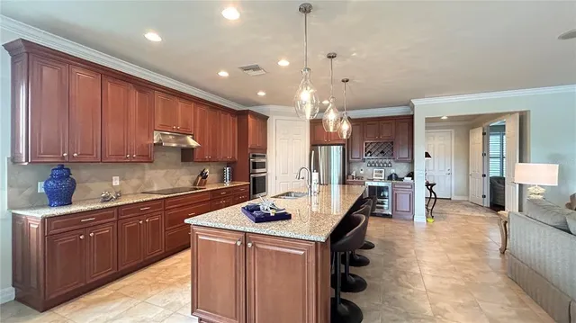 a kitchen with granite countertop a center island stainless steel appliances cabinets and a counter top space