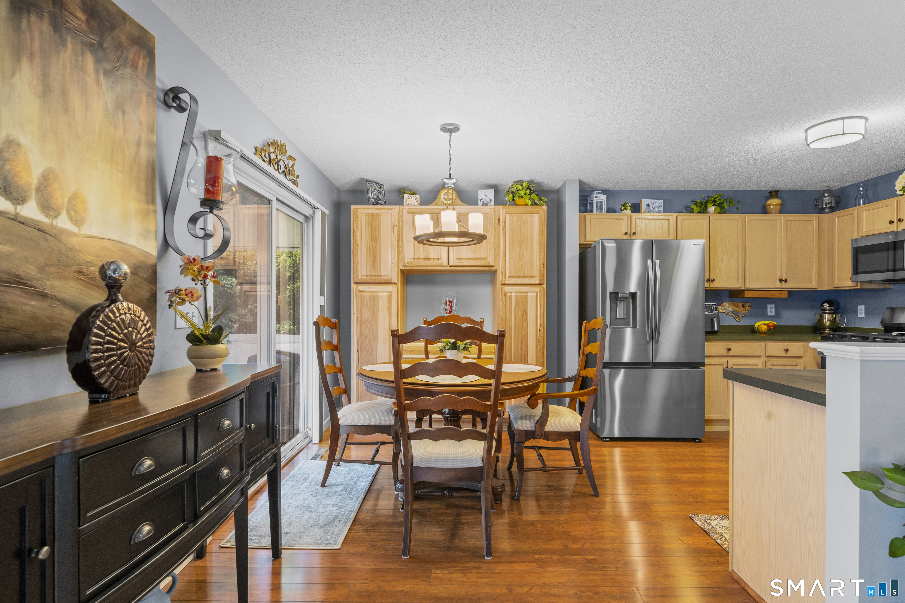 7 Heather Lane, Unit 7 Suffield, CT 06078 - Photo 9 of 34 a kitchen with stainless steel appliances granite countertop a stove top oven a refrigerator a dining table and chairs with wooden floor