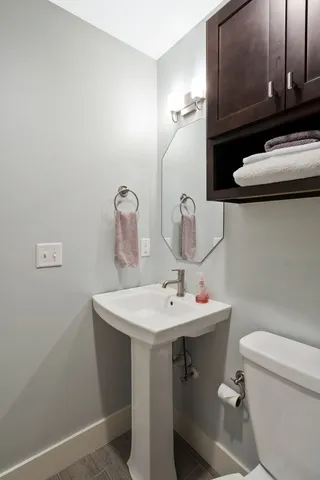 a bathroom with a sink a toilet and mirror